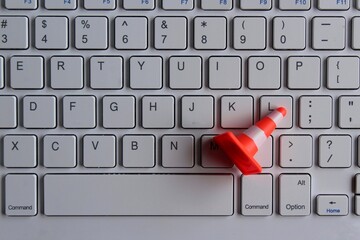 Computer system under construction, maintenance, repair concept. Safety cone and keyboard computer