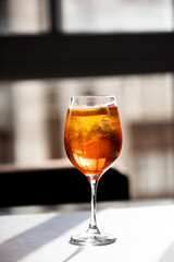 photography of aperol spritz cocktail glass with orange slice photo taken with light and shadow