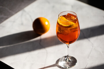 photography of aperol spritz cocktail glass with orange slice photo taken with light and shadow