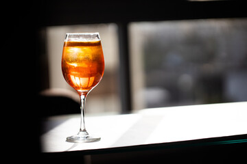 photography of aperol spritz cocktail glass with orange slice photo taken with light and shadow