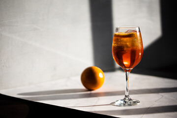 photography of aperol spritz cocktail glass with orange slice photo taken with light and shadow