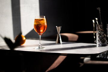 photography of aperol spritz cocktail glass with orange slice photo taken with light and shadow