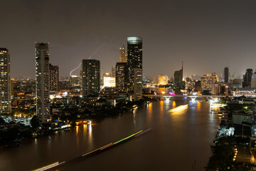 Cityscape background of Bangkok city, Thailand along the Chao Phraya River at night.