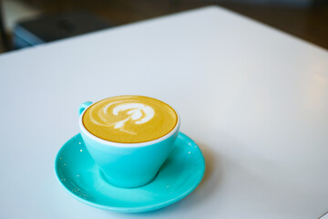 a cup of late coffee with flower shape design on top at cafe 