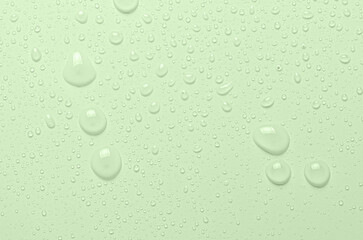 Drops of micellar water or cosmetic tonic on a green background. Close-up, macro photography