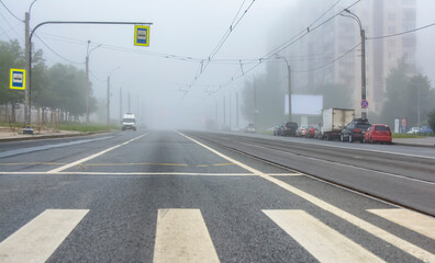City street on a foggy morning with traffic.
