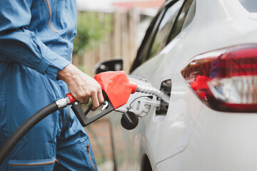 Gas station workers are refueling cars, fuel consumption, gasoline-powered cars, fluctuating oil...