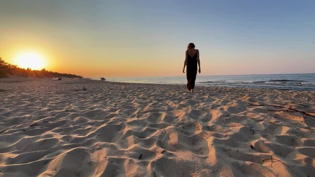 KOBIETA SPACERUJE BRZEGIEM MORZA. SAMOTNA KOBIETA SPACERUJĄCA NAD MORZEM.
KOBIETA SPACERUJĄCA PO MORSKIEJ PLAŻY.
