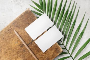 Clean minimal business card mockup on wood plate with leaves and pencil