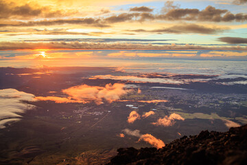 Early morning sun hits cloud puffs near summit of Mt. Fuji