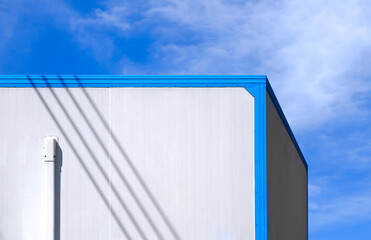 Fototapeta na wymiar Air conditioning pipeline on white wall of office container against cloud on blue sky background