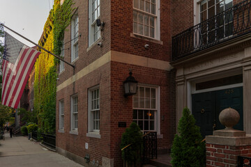 American flag on old building facade and street view in the evening. High-quality photo