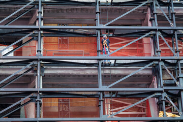 A man stands backward on the scaffolding, the city's new construction and renovation concept. New York . High-quality photo
