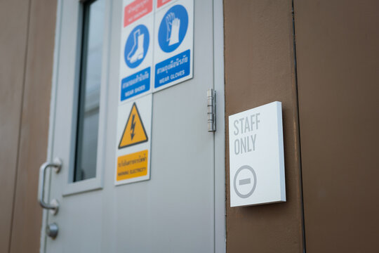 Staff only restricted area sign with safety placard icon on the metal door of swtichgear control room. Sign and symbol for industrial working place object photo, selective focus.