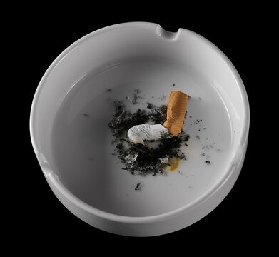 Cigarette stub, matches and ash in ashtray isolated on black 