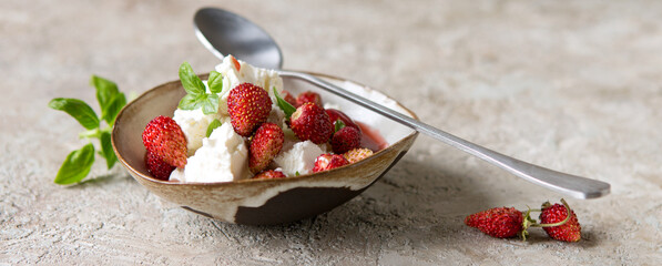 ceramic bowl with mascarpone, strawberry and basil dessert on light table