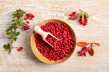 Pile of Berberis vulgaris also known as common barberry, European barberry or barberry on plate in home kicthen. Edible herbal medicinal fruit plant.
