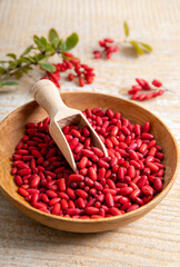 Obraz na płótnie Canvas Pile of Berberis vulgaris also known as common barberry, European barberry or barberry on plate in home kicthen. Edible herbal medicinal fruit plant.