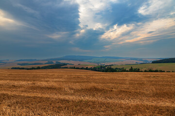 Fototapeta premium Beautiful hilly landscape around the village of Kunkovice in the Czech Republic in Europe. There are dramatic clouds in the sky.