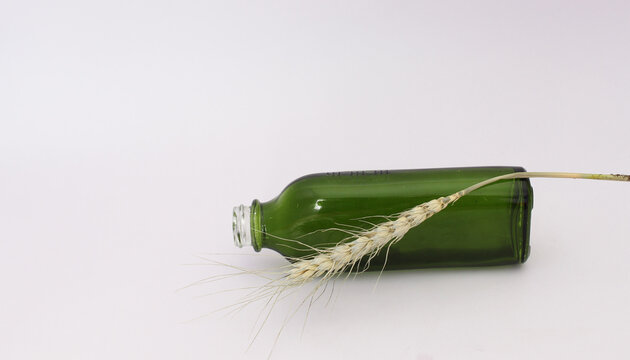 Envase de vidrio en color verde y forma rectangular para uso de productos cosmeticos