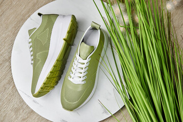 Stylish green female shoes on white background in shop, copy space. New sneakers on the floor, close up. Beauty and fashion concept. Flat lay, top view. Overhead shot