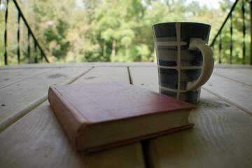 Hot drink with coffee or tea and a classic book for reading, study, or meditation in a quiet, calm,...