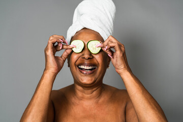 Happy African senior woman having skin care spa day - People wellness lifestyle concept