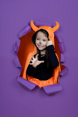 Laughing funny child girl in a devil  costume in halloween