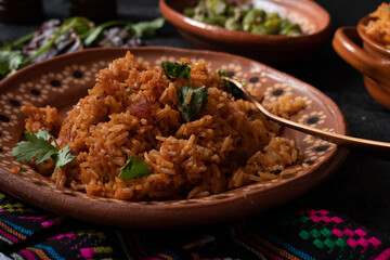 Mexican rice served in traditional clay pot and plate