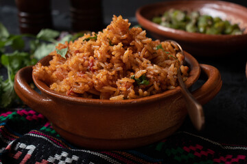 Mexican rice served in traditional clay pot and plate
