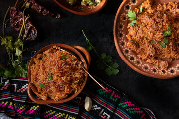 Mexican rice served in traditional clay pot and plate