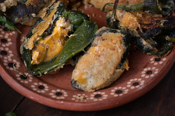 Chilles rellenos served in traditional mexican dishes, served with beans, pickles