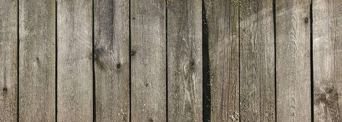 Wooden texture with horizontal lines. The texture of wood with knots and holes. The background of a wooden fence damaged by time. Banner of an old wooden fence.