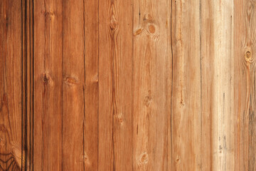 Wooden texture with vertical lines. The texture of wood with knots and holes. The background is made of a wooden fence of natural color. Red wooden background.