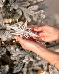the concept of holidays and people - close-up of hands and a toy decorating the Christmas tree.