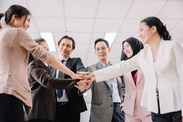 Group business team showing unity and power with their hand's success together at the office.