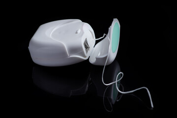 Container with dental floss. Floss on black background. White dental floss case isolated. Open dental floss container