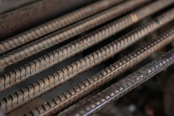Stack of heavy metal reinforcement bars with periodic profile texture.
