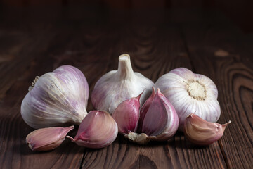 Garlic cloves on wooden table. Fresh peeled garlics and bulbs.