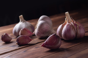 Garlic cloves and bulb on wooden table. Fresh peeled garlics and bulbs.
