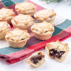 Traditional British Christmas mince pies with fruit filling, on festive cloth, square format