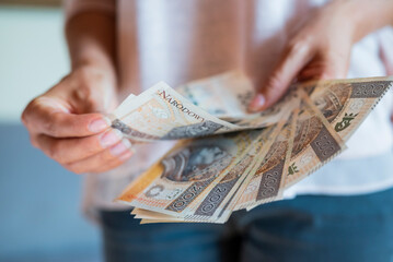 the girl holds in her hands banknotes money polish zlotys and pennies coins salary for payment