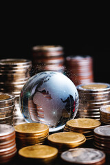 Globe and stack with coins. Money makes the world go round, world money concept. vertical.