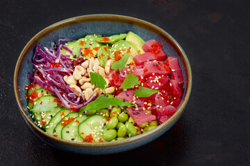 Top view on poke salad with tuna and green vegetable in the bowls on gray background. Copy space.