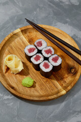 Different types of delicious and juicy sushi and rolls on a wooden board