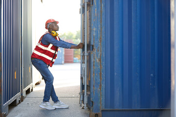 African factory worker or foreman opening the container door in warehouse storage