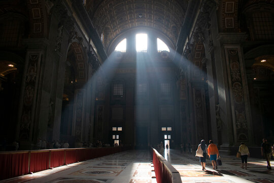 Promienie słoneczne wpadające przez witraż w bazylice św. Piotra w Rzymie