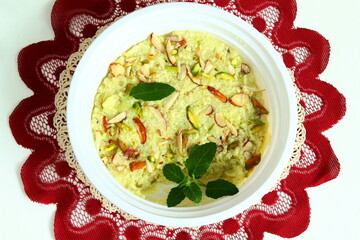 indian gujarati traditional sweet or mithai dudhi halwa or burfi pak made from bottle gourd (dudhi lauki) in dish with dry fruit garnish,top view