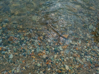 clear river water above stones lying beneath