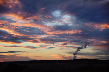 Sunset sky colorful clouds and smoke from pipe